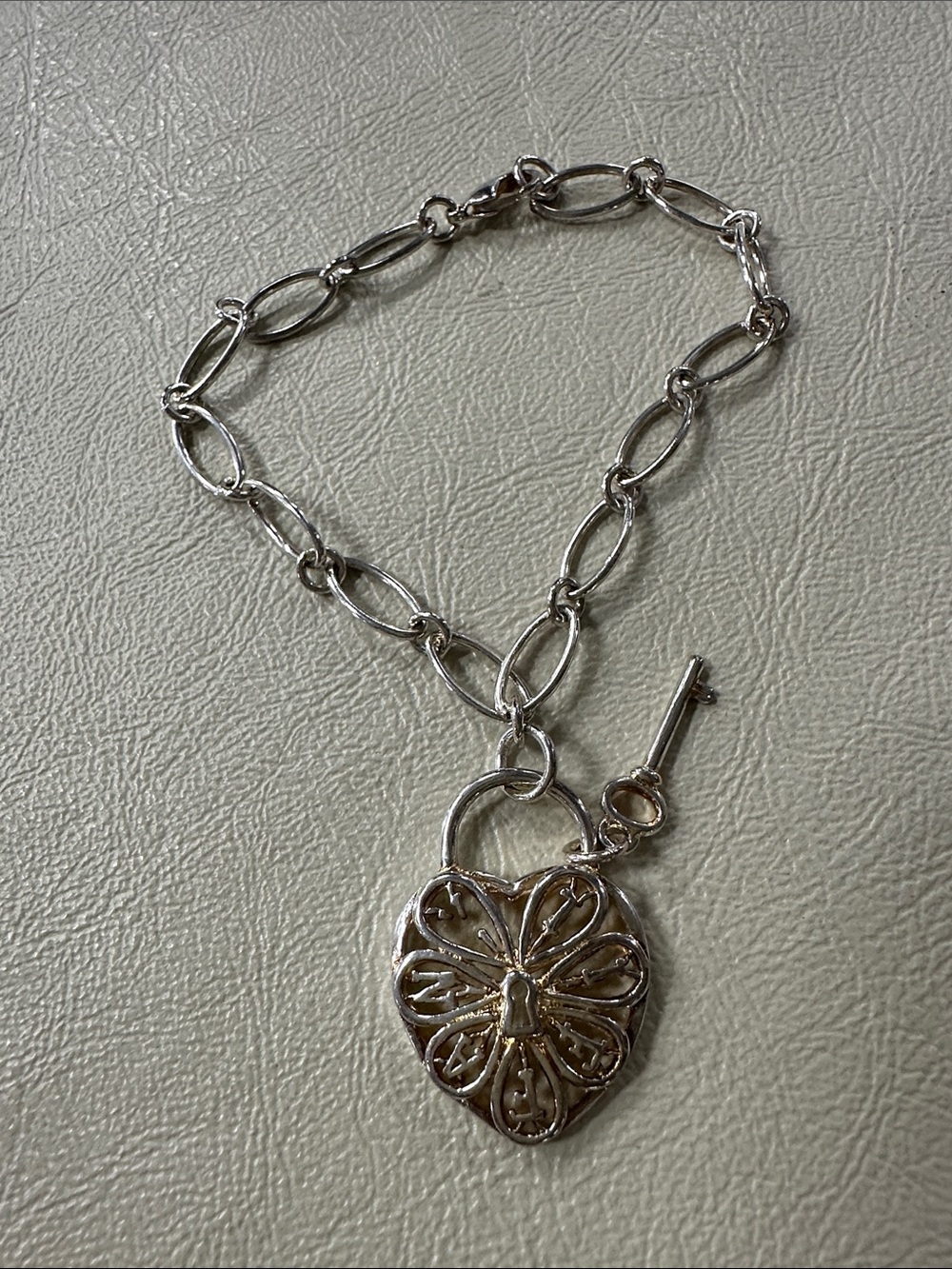 Tiffany & Co. sterling silver filigree heart key lock charm bracelet. 8”